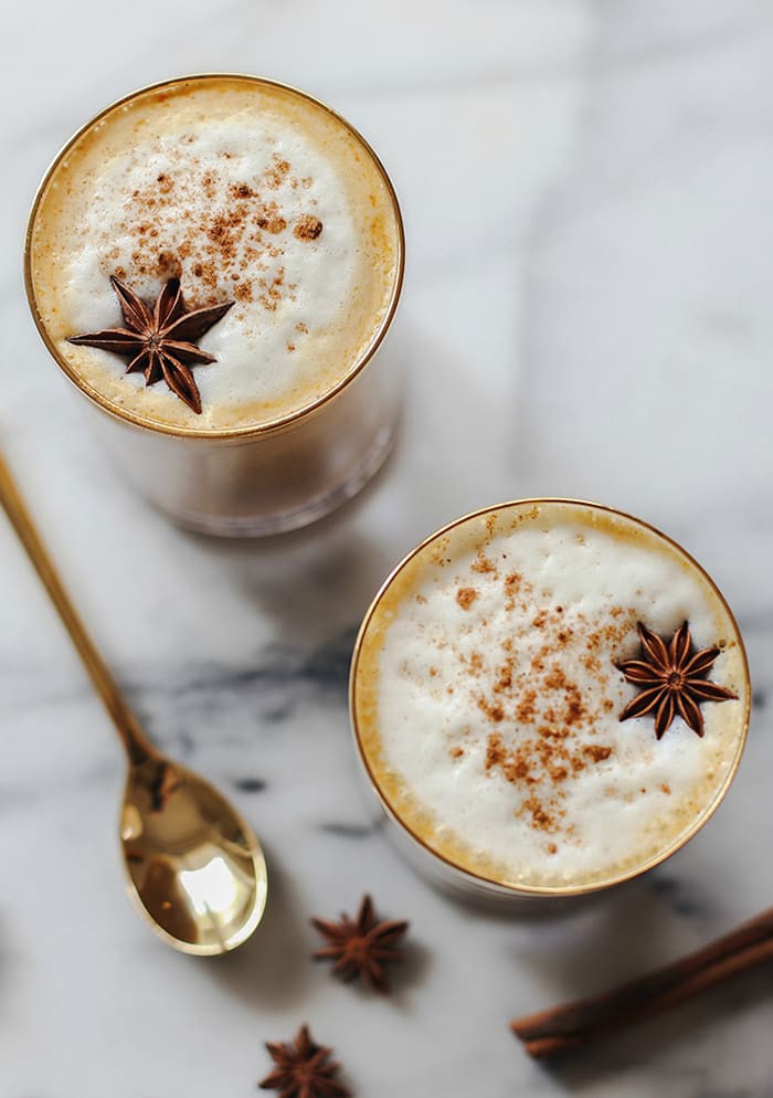 pumpkin spice cocktail in two glasses with a gold spoon