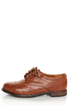 The Dollhouse Trickster Chestnut Brogue Lace-Up Oxfords are the quickest trick to a flawless \\\'fit! Tan vegan leather oxfords with brogue details and coated shoestrings.