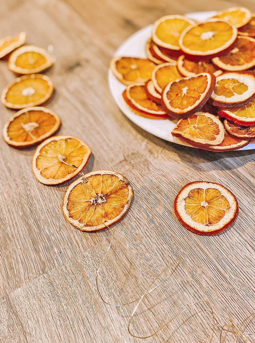 stringing dried orange slices