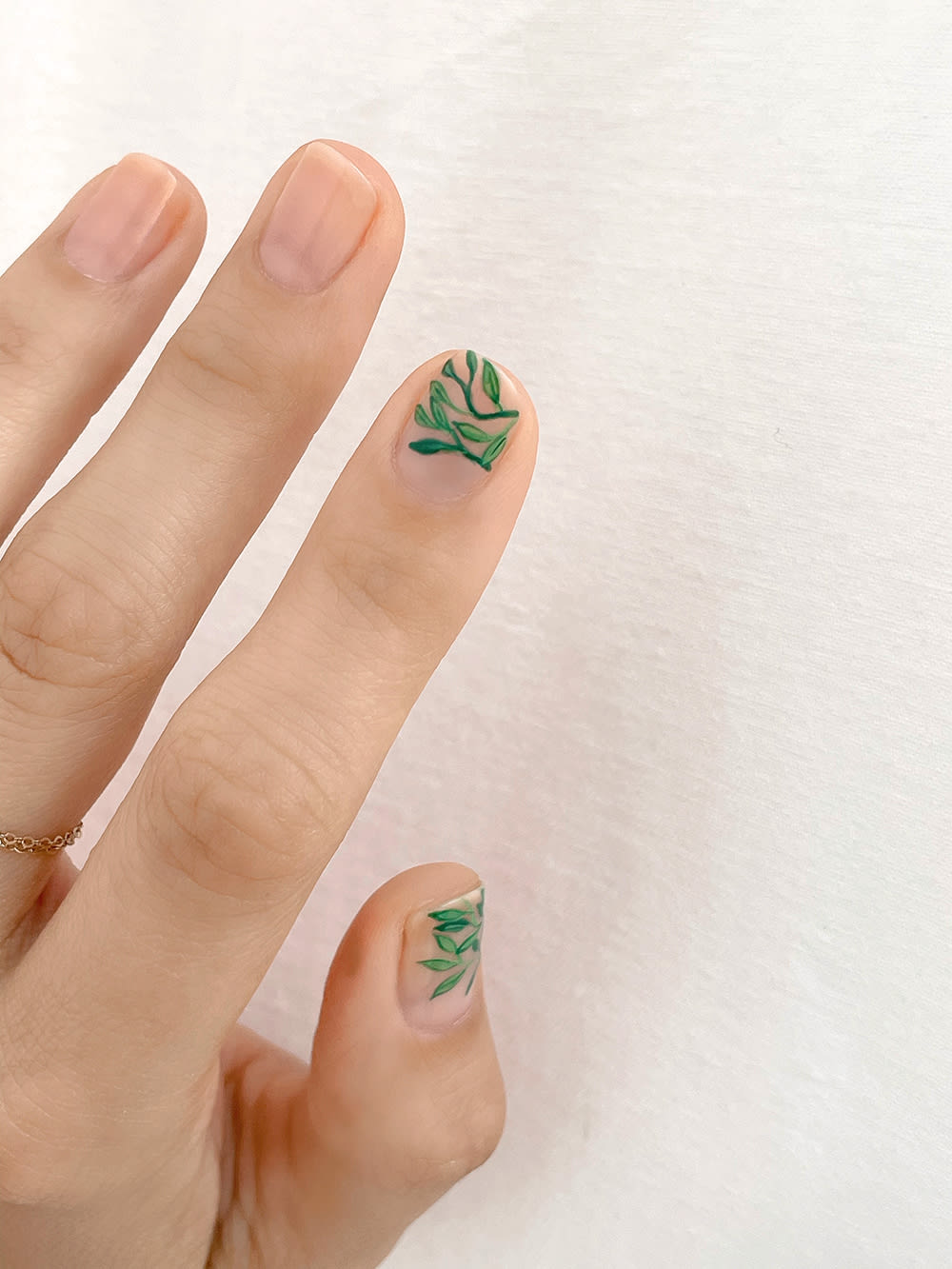 leaves outlined on pointer and thumb floral nail art 