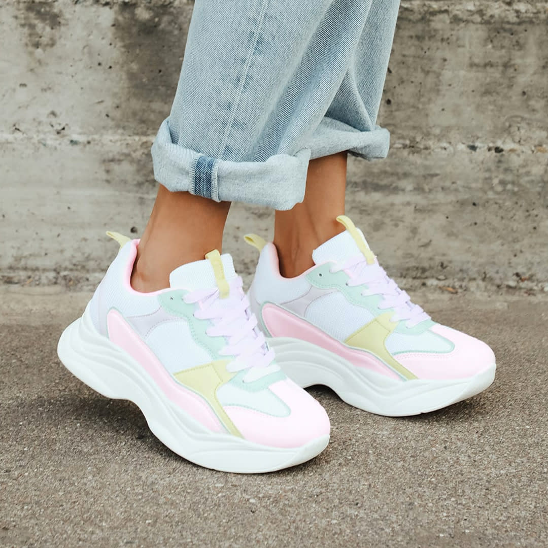 feet wearing chunky multicolor sneakers
