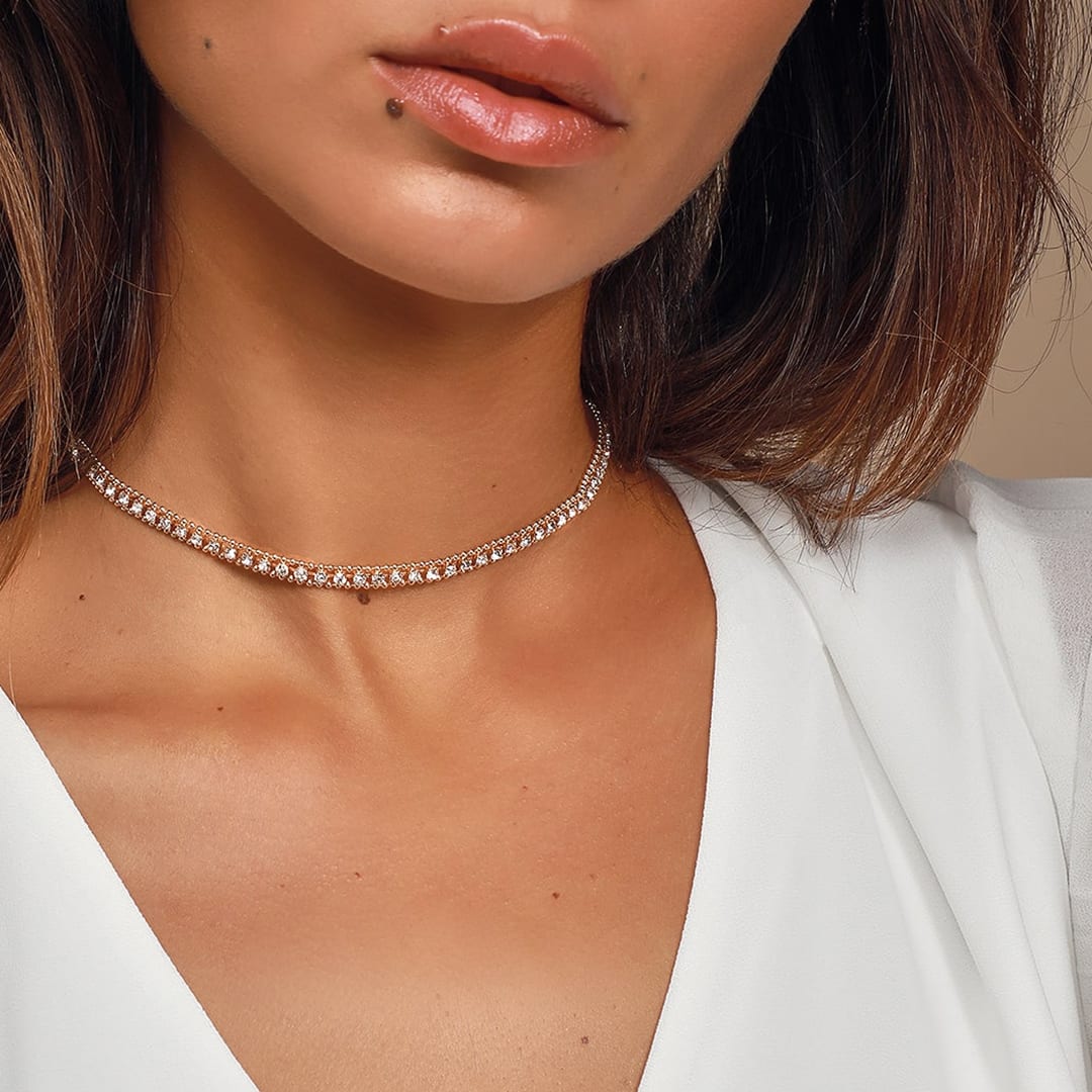 a gold rhinestone choker necklace on a woman's neck