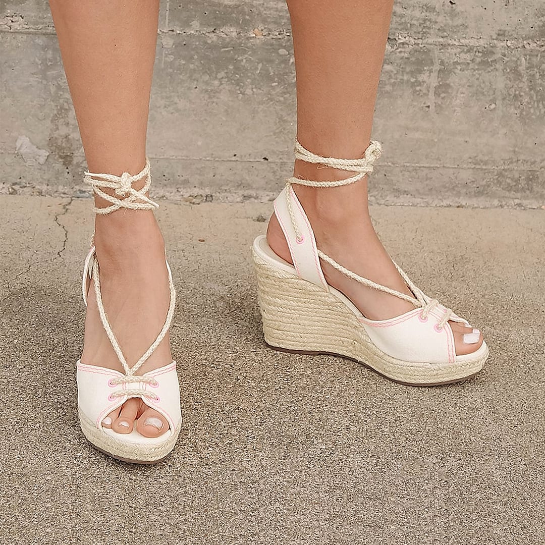light nude leather lace up espadrille wedges on a womans feet