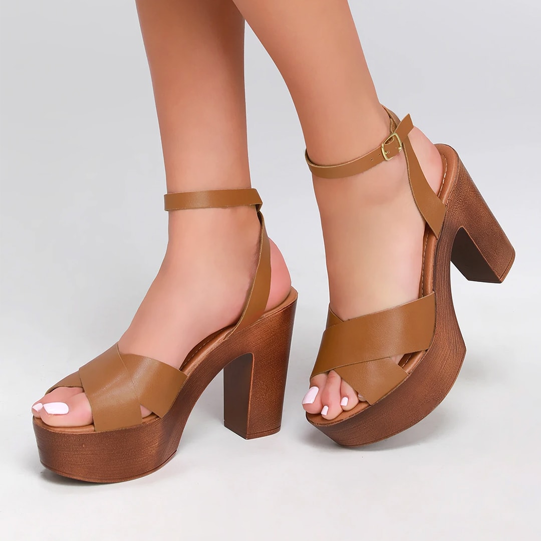 feet wearing brown leather platform ankle strap sandals