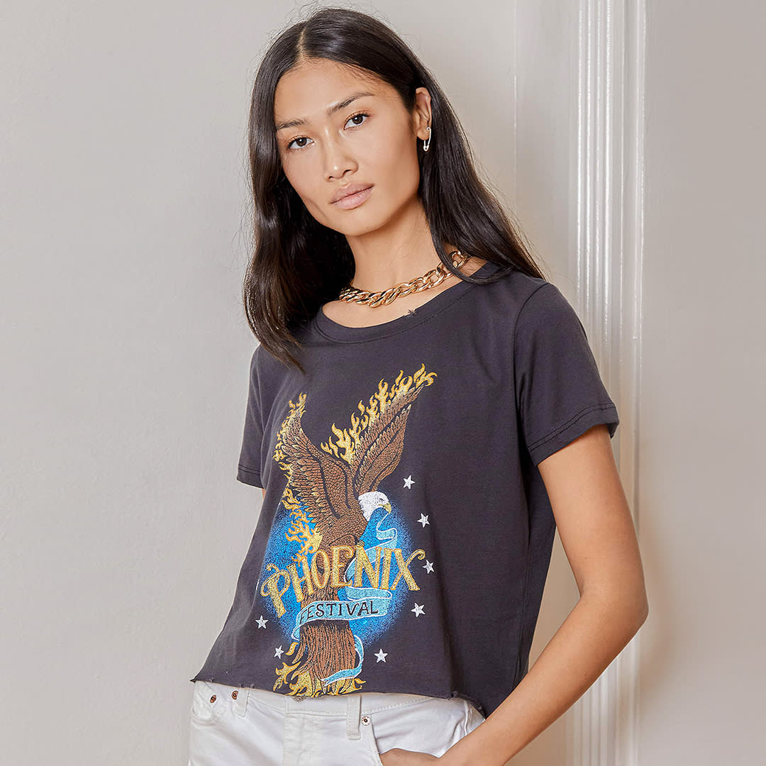 a model in a black cropped graphic tee with rock band logo