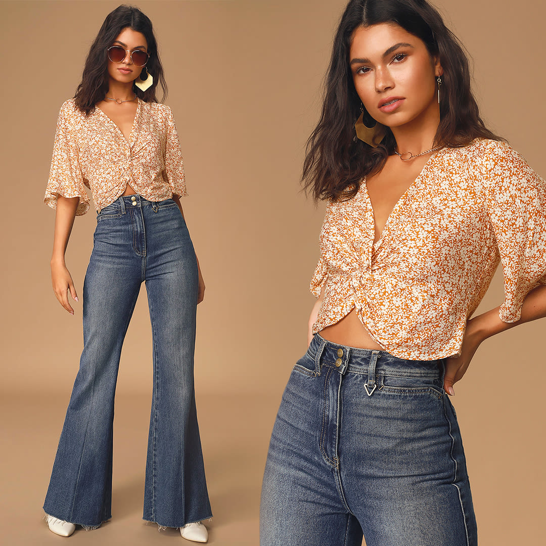 a woman in 70s inspired flare jeans and a mustard yellow floral print twist front top
