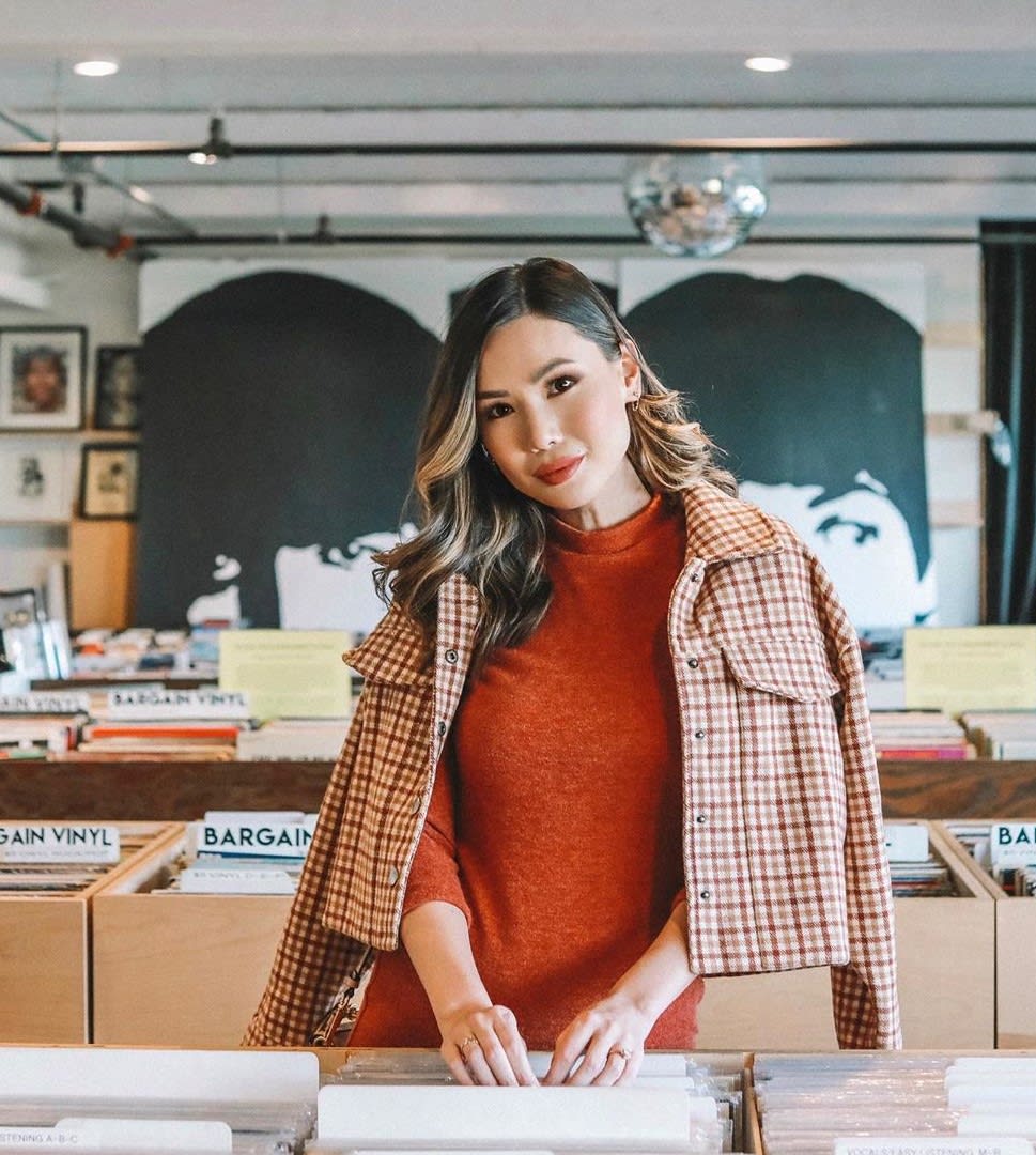 woman in rust turtleneck and plaid jacket