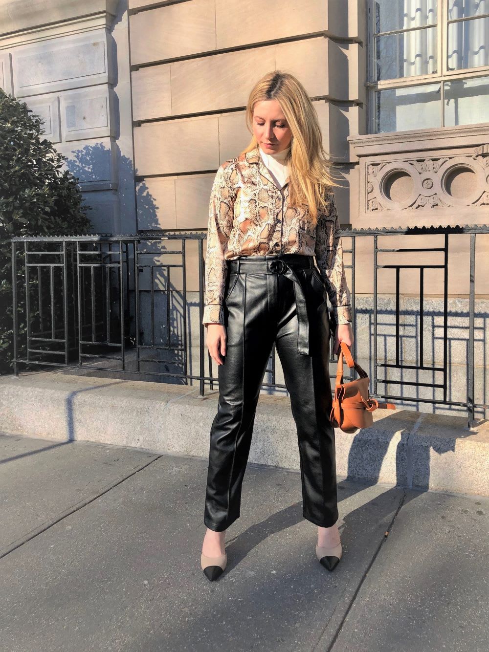 blouse over turtleneck and leather pants show how to layer for winter fashionably