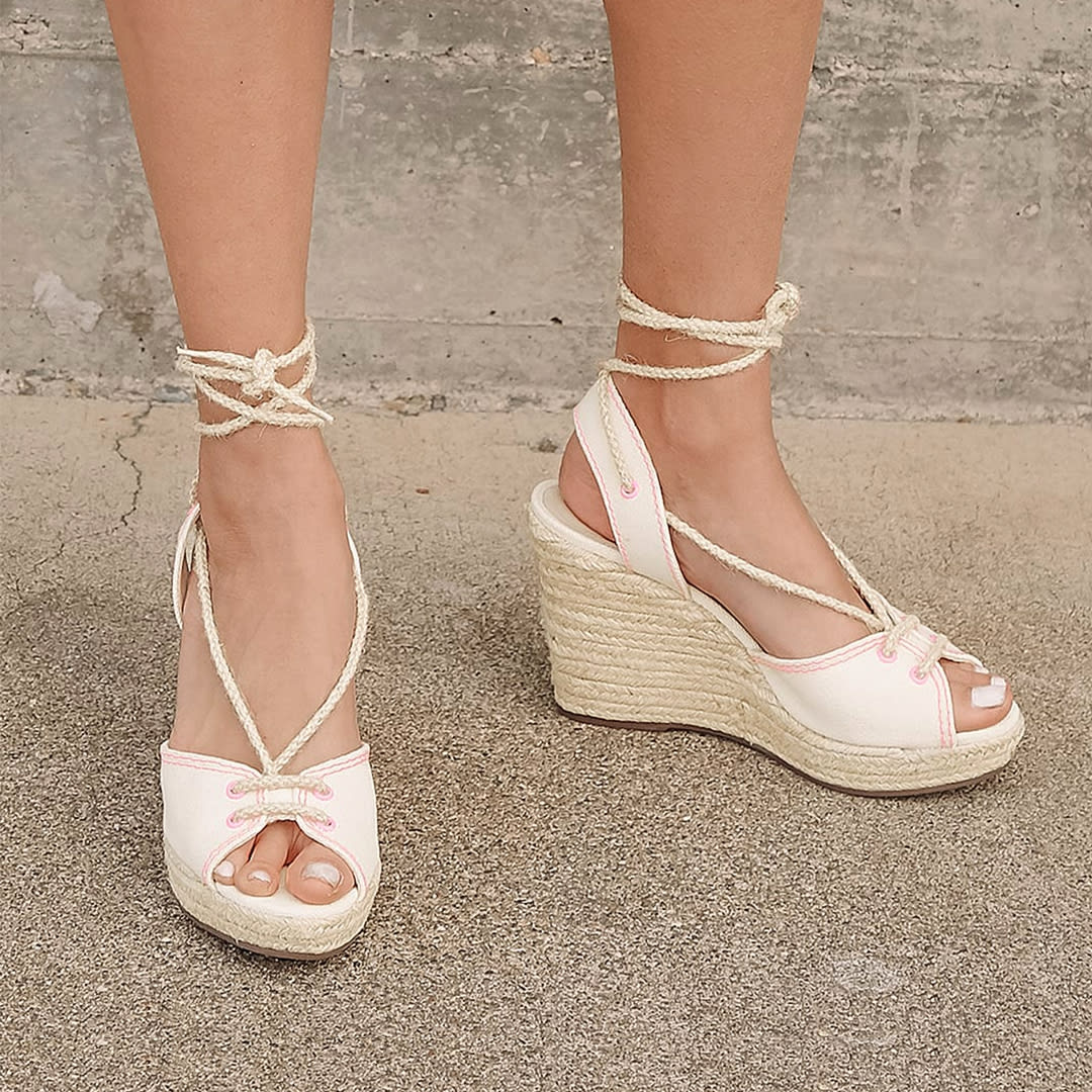 feet wearing light nude lace up espadrille wedges