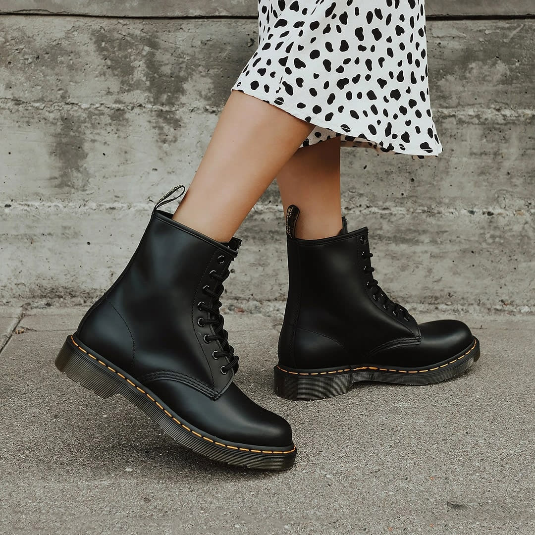 hem of a cheetah print skirt on a woman wearing chunky black doc maartens boots