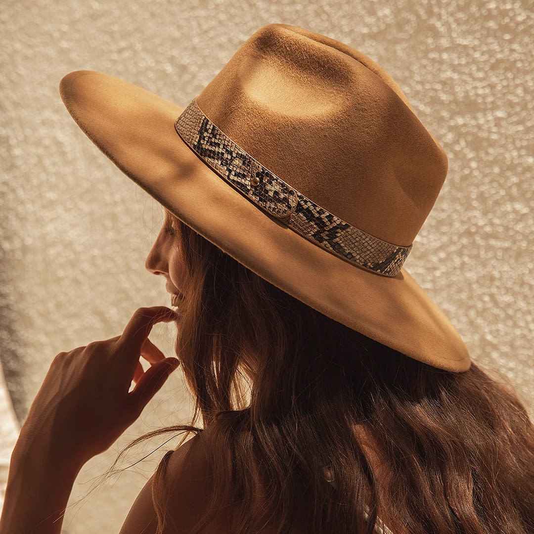 a model wearing a brown wool wide brim hat with a leopard band
