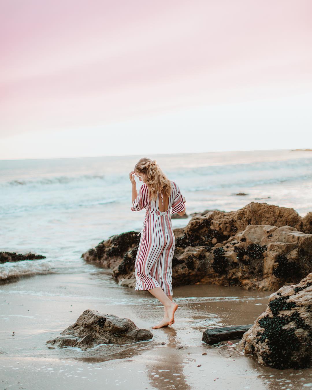 women in striped jumpsuit in ocean at sunset- natural cleaning products brands