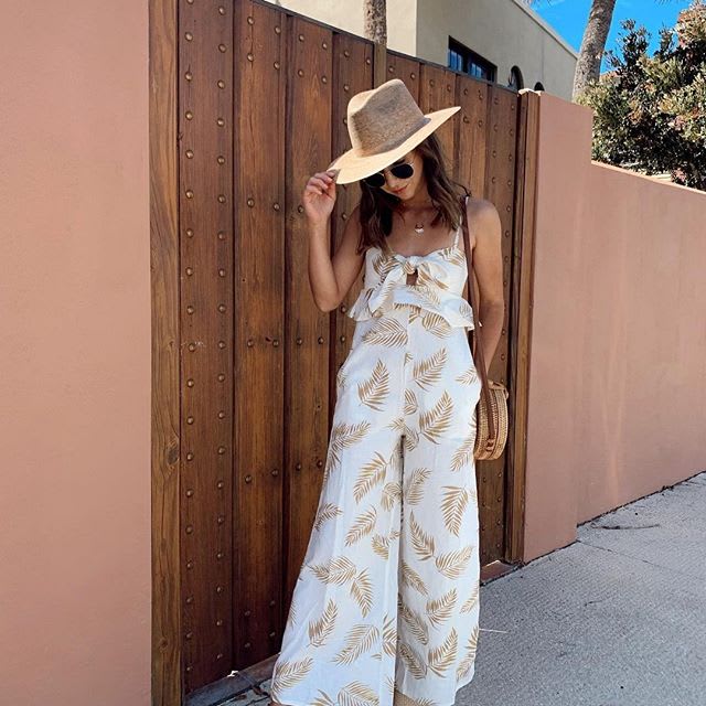 woman wearing a leaf print jumpsuit and a straw hat: how to pick sunglasses for your face shape : sunglasses for your face shape- how to choose sunglasses for your face- how to find the perfect sunglasses -how to find perfect sunglasses for your face- how to find the perfect sunglasses for your face shape