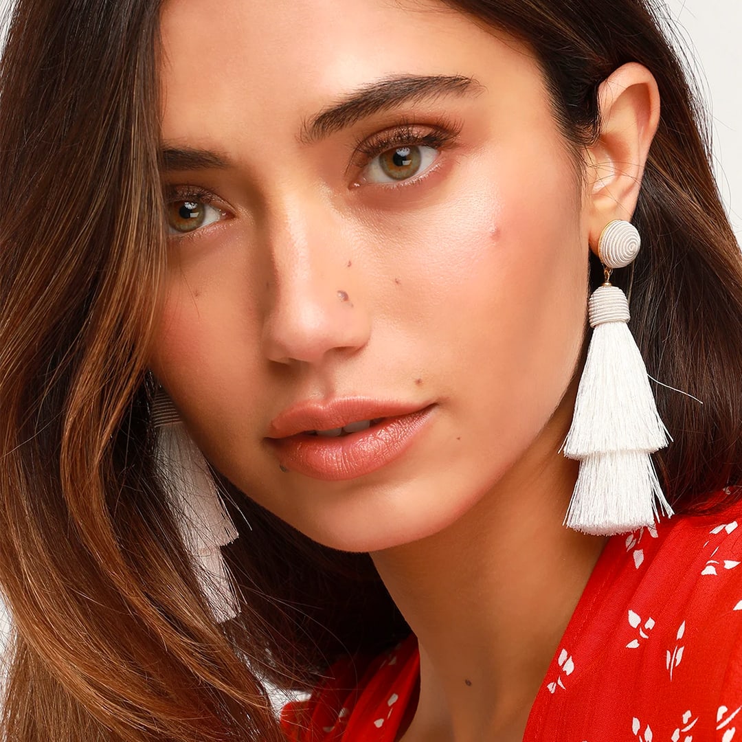 model wearing ivory tassel earrings