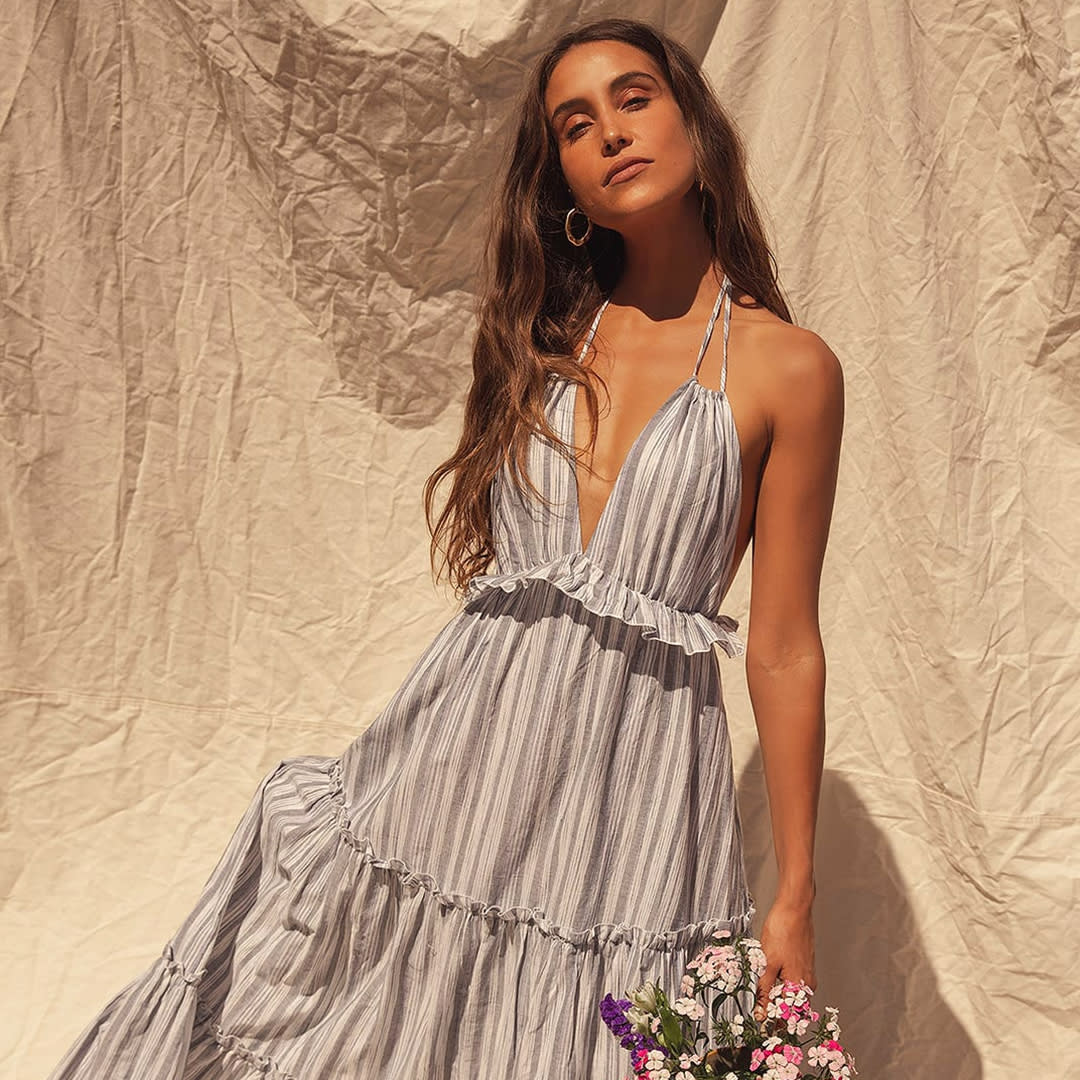 a model wearing a grey striped halter maxi dress