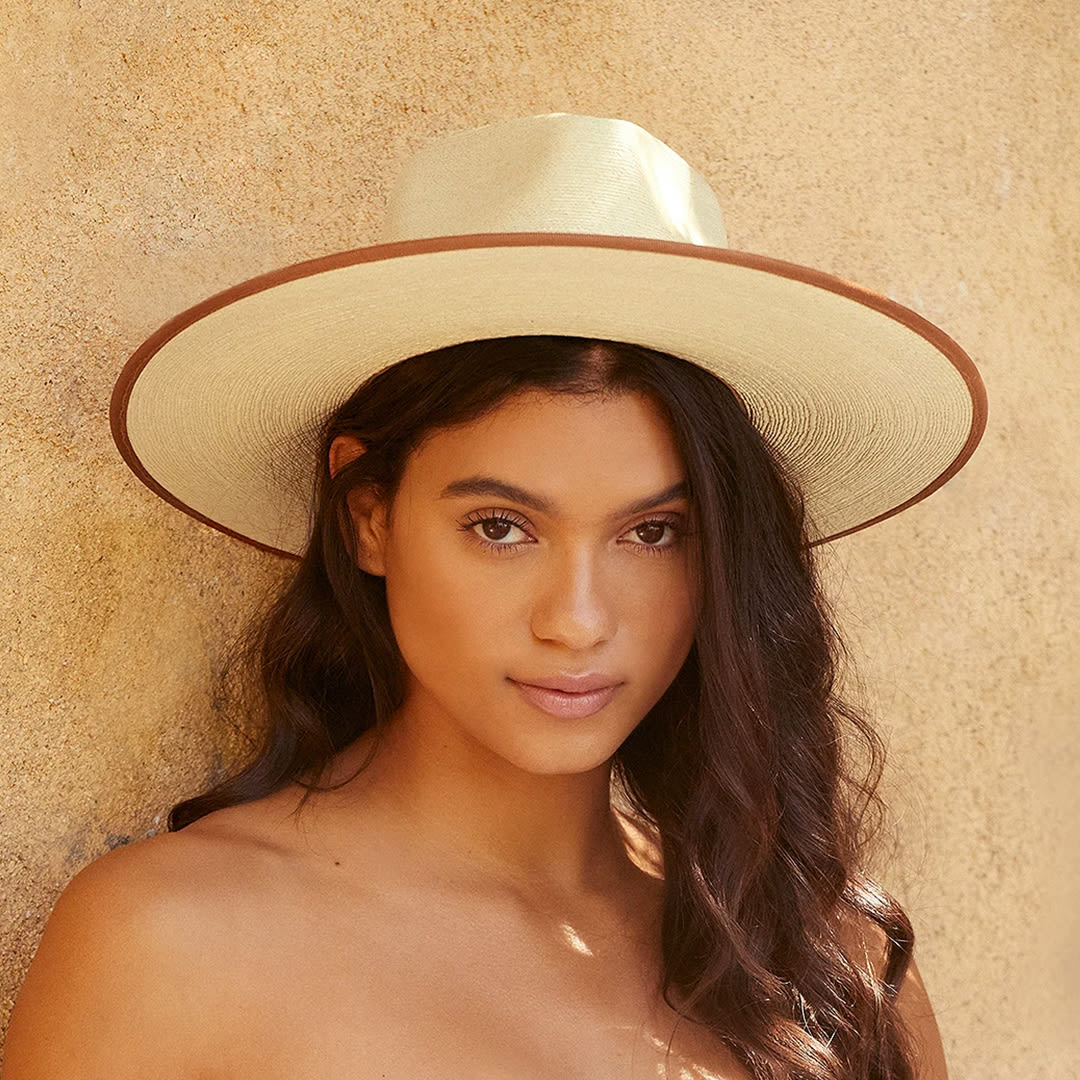 a model wearing a tan straw rancher hat