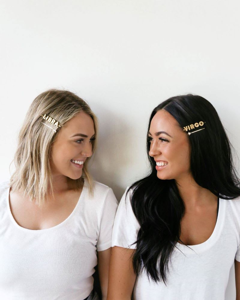 blonde and brunette woman wearing gold hair pins that say libra and virgo from diy hair accesssories tutorial