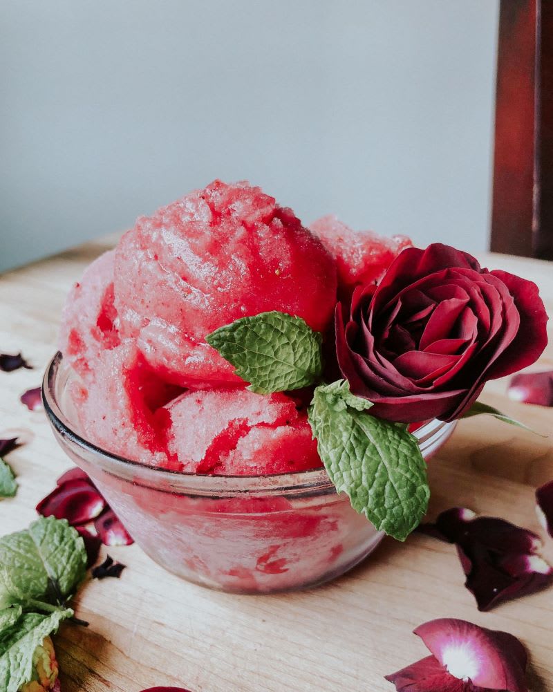 rosé sorbet in bowl with rose and petals for rose sorbet recipe 