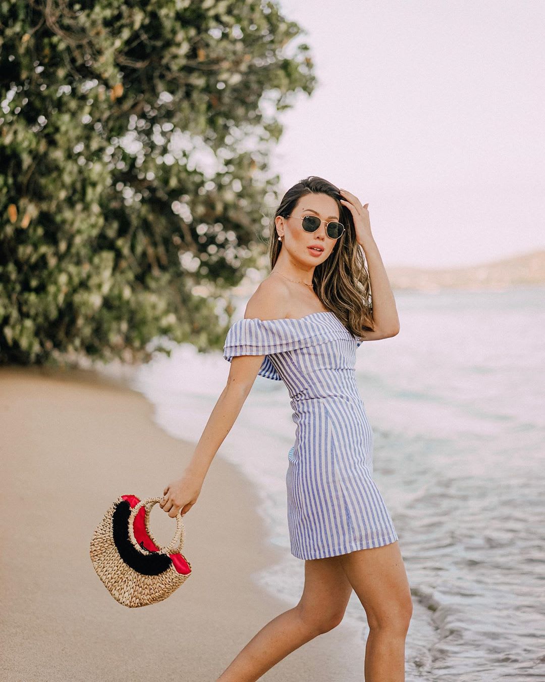 woman wearing an off the shoulder blue and white striped dress