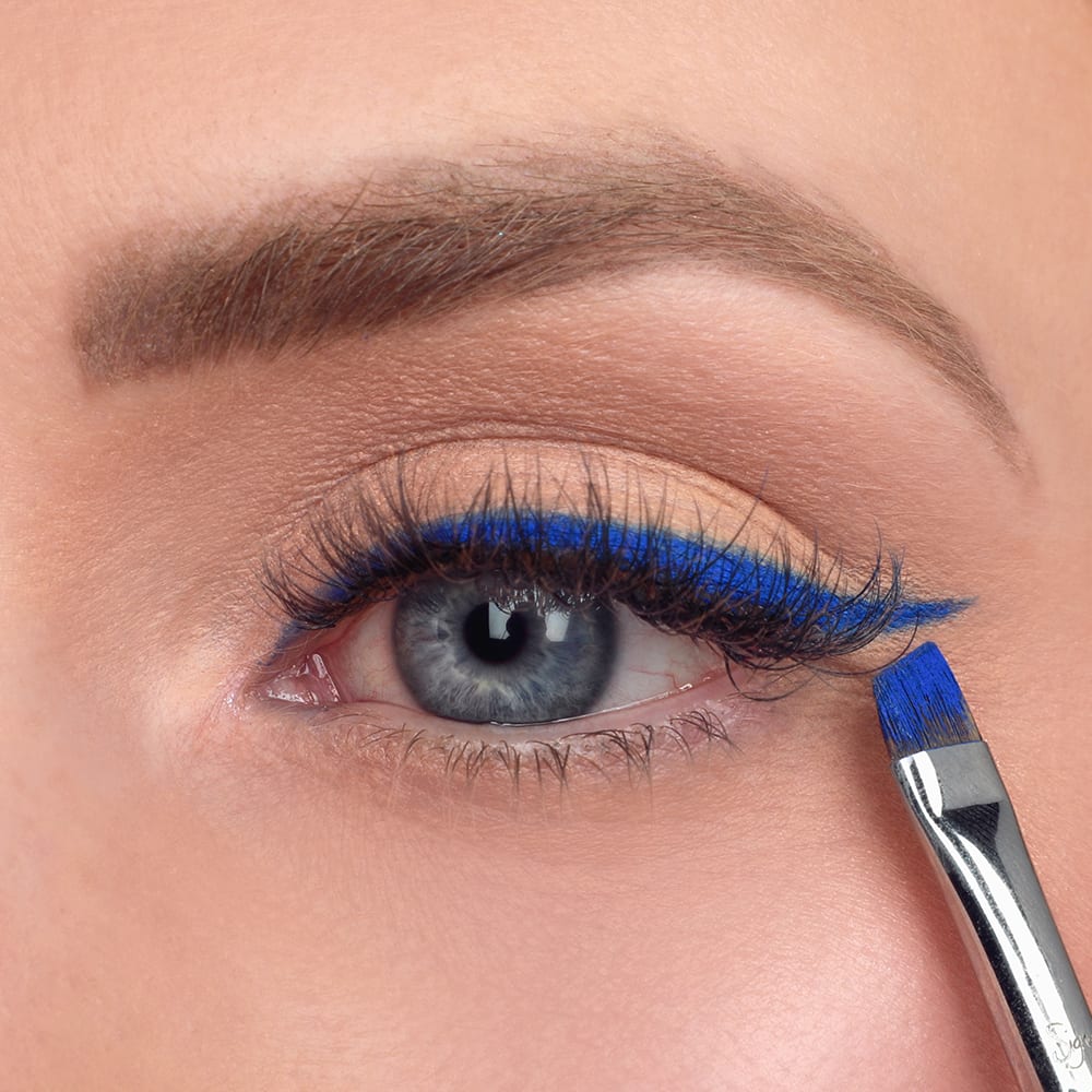 applying bright blue eyeliner