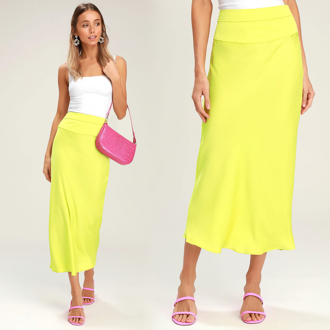 model wearing a white tank top with a neon yellow satin skirt and pink shoulder bag