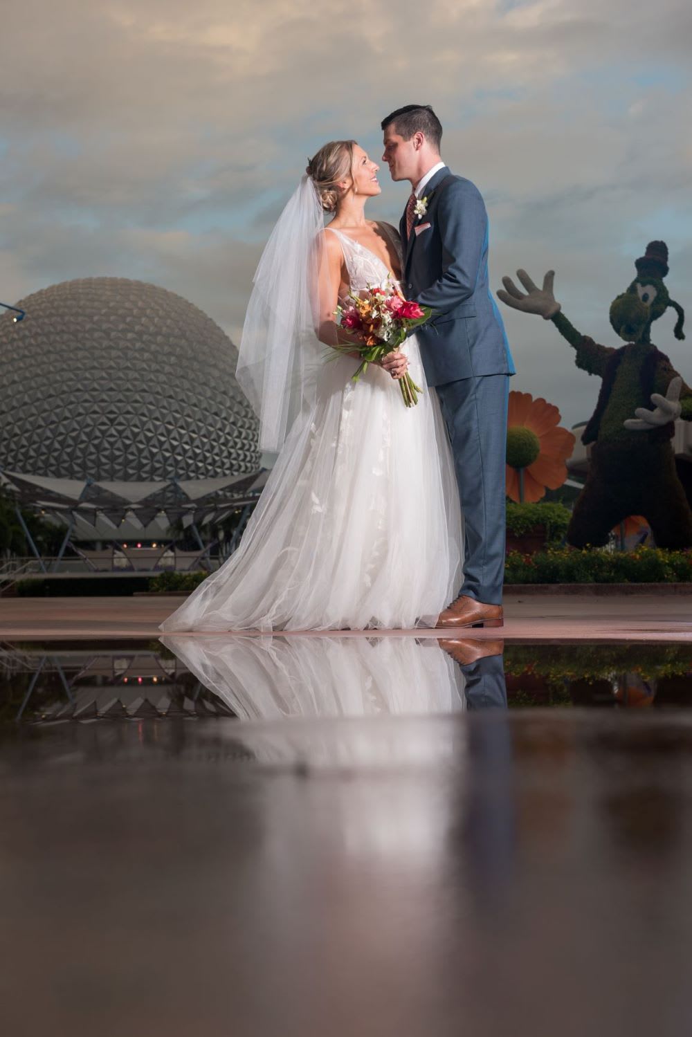 couple in front of Epcot while getting married at disney world