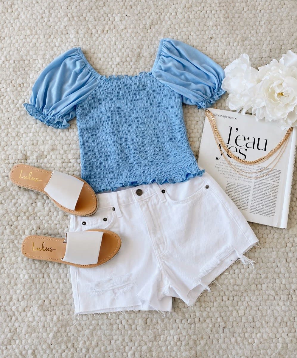 blue smocked top with white shorts and white slide sandals