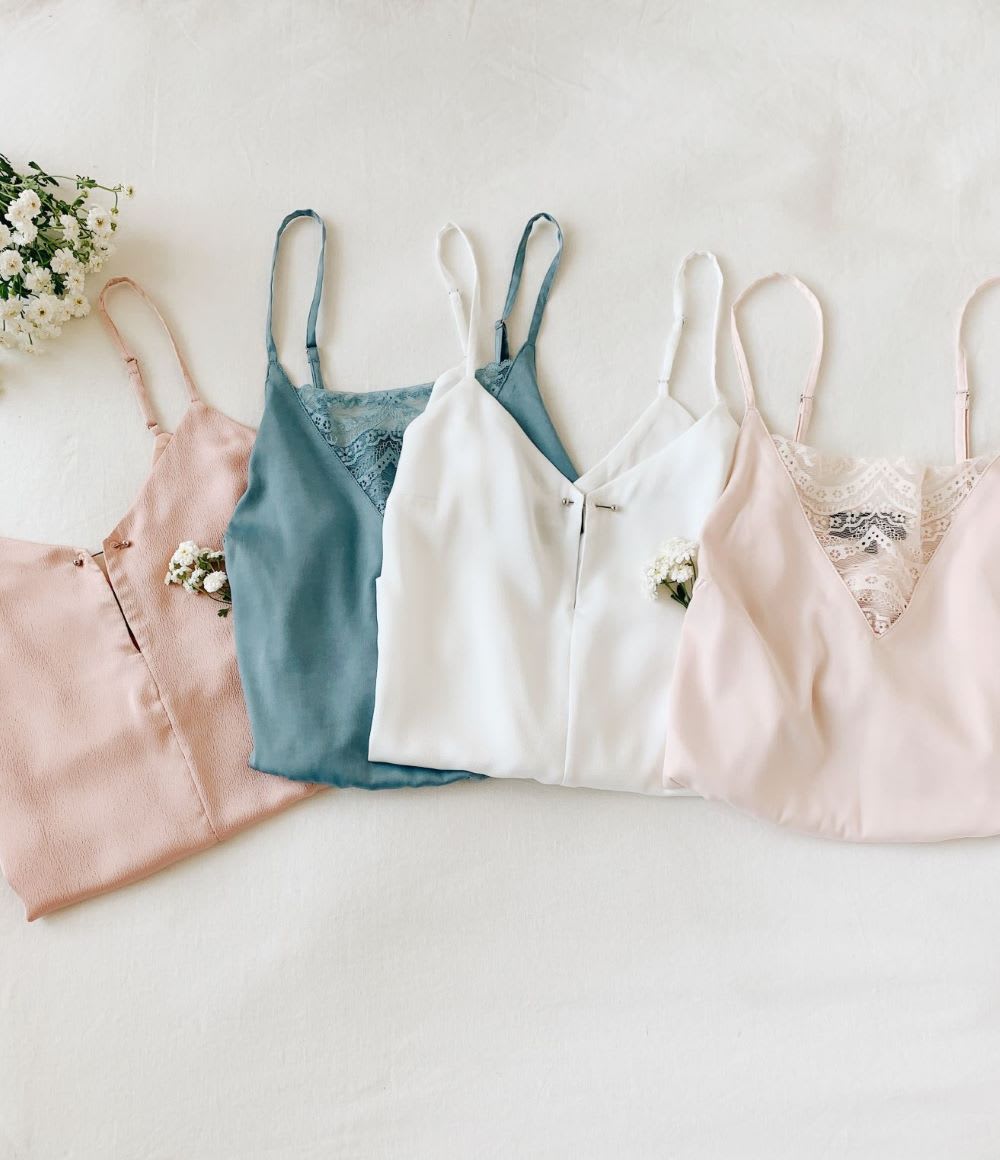 pink, blue, and white satin cami tops laid flat