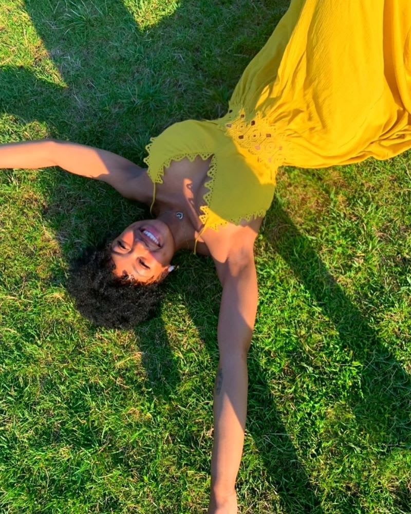 woman laying on the grass in a yellow dress