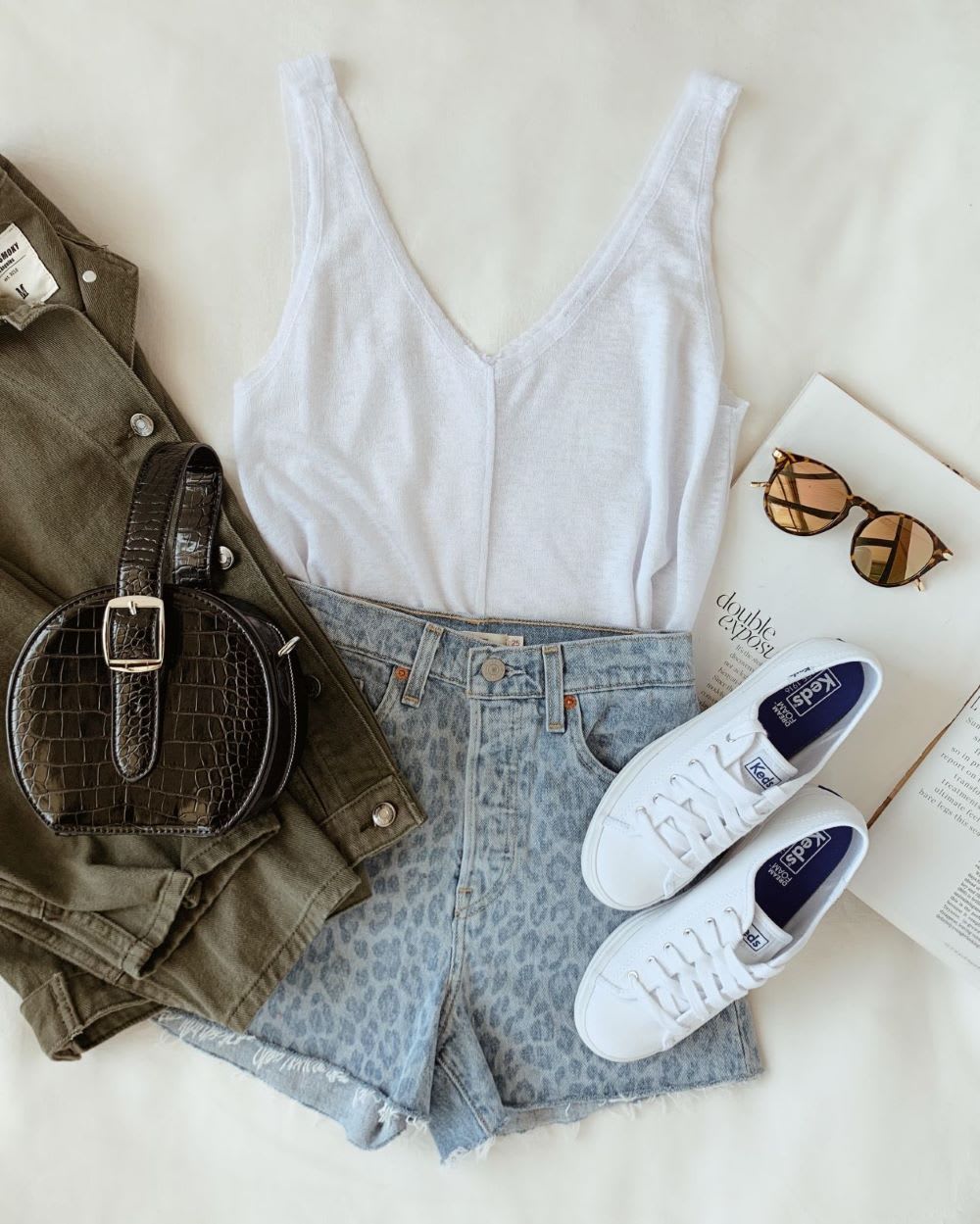 green army jacket with white tank, leopard print denim cutoff shorts, black top handle bag, white sneakers, and mirrored sunglasses
