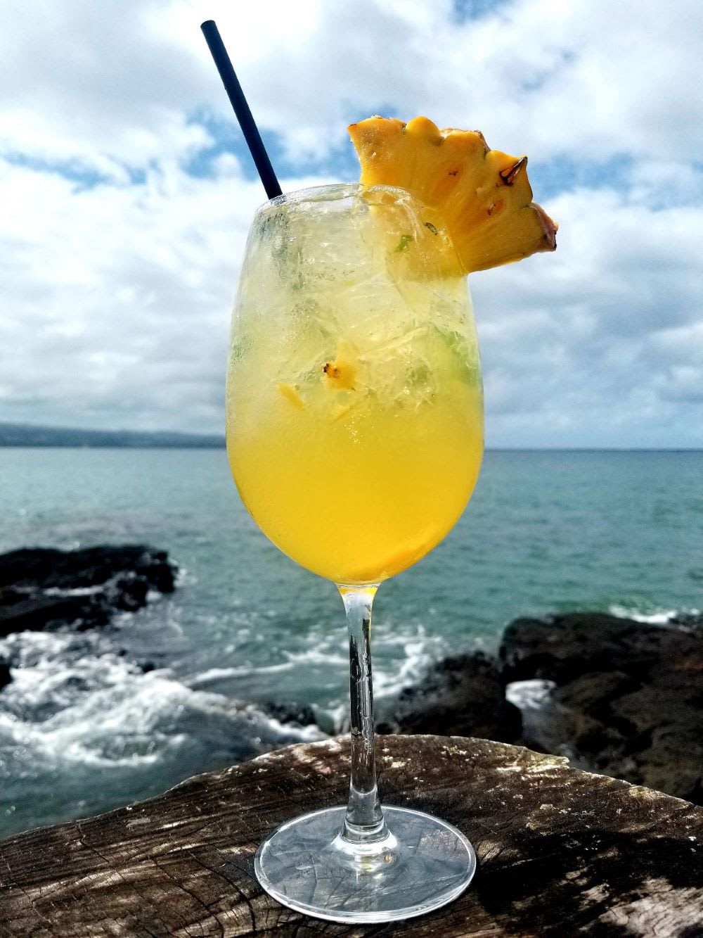 topical cocktail in front of ocean in hawaii