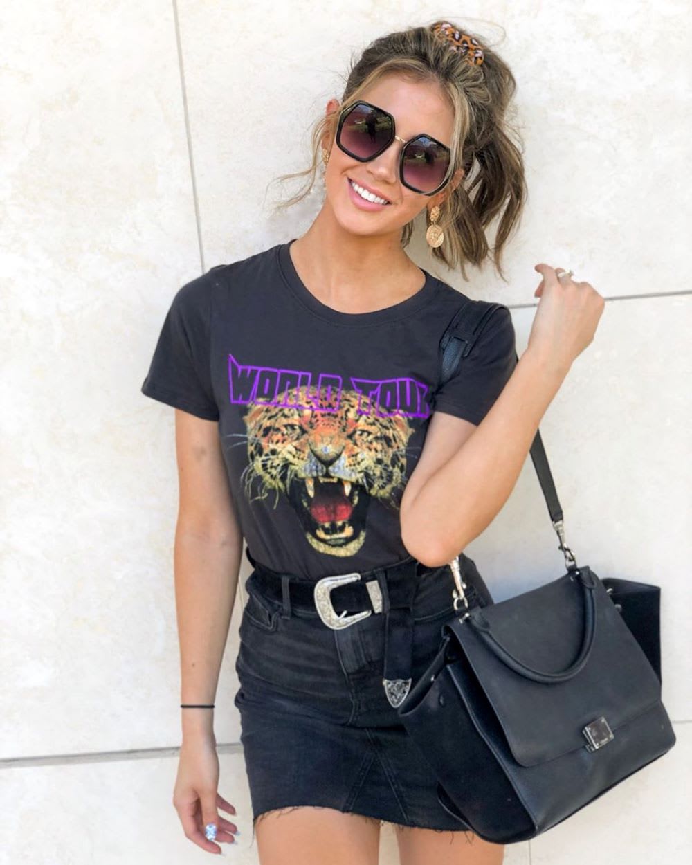 woman in black tour graphic tee and denim skirt for summer songs playlist