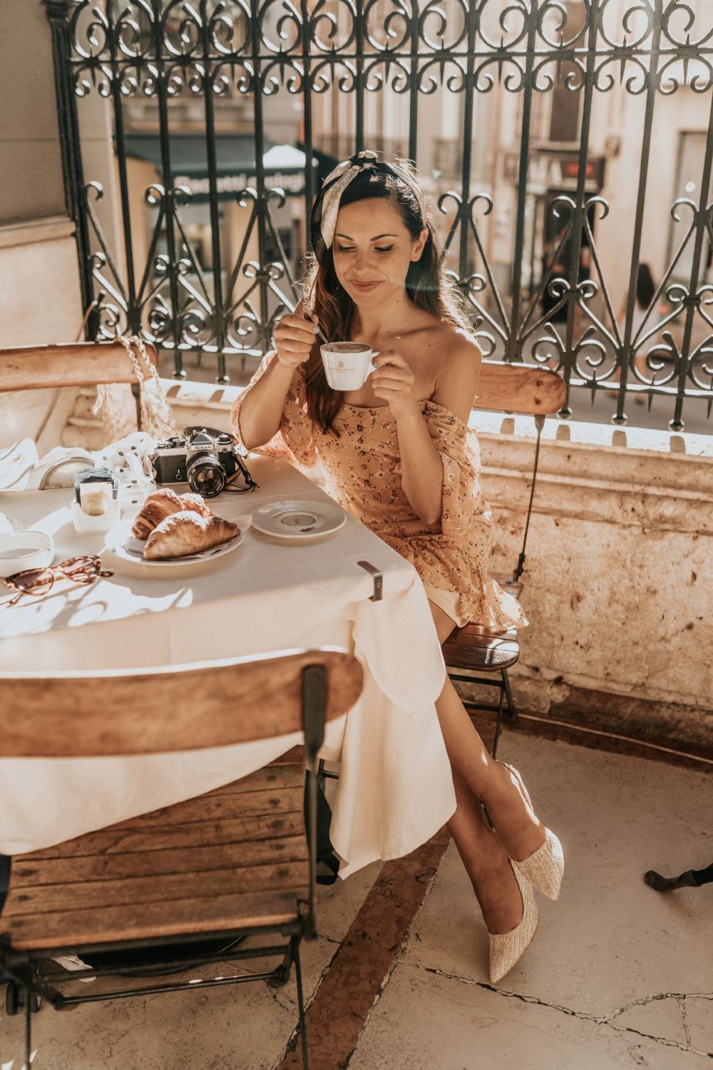 woman sitting at a table sipping coffee as part of sardinia travel guide