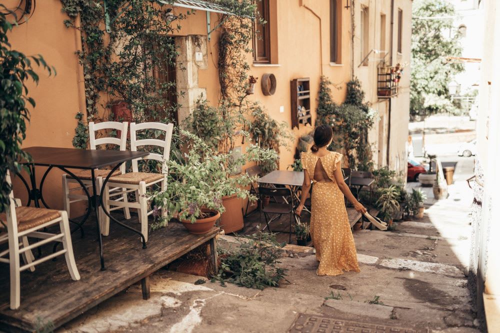 woman wearing a yellow floral maxi dress walking in Sardinia