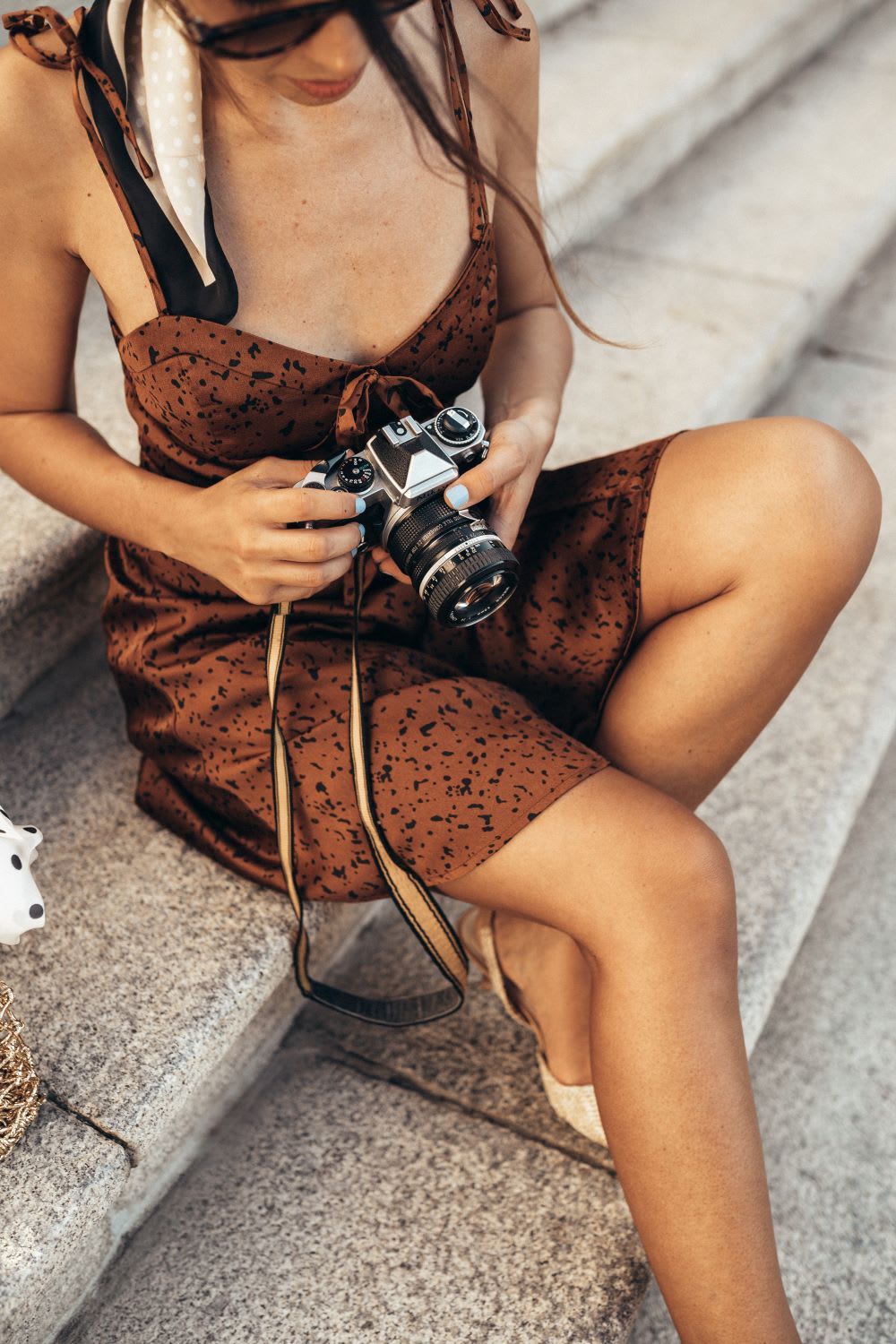 detail shot of woman wearing satin slip dress with camera for sardinia travel guide