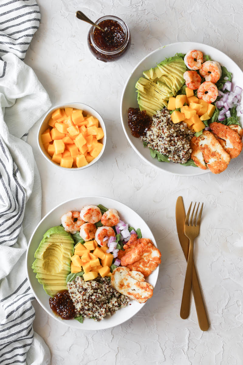 two bowls of shrimp and mango salad with fried halloumi cheese and fig jam on the side