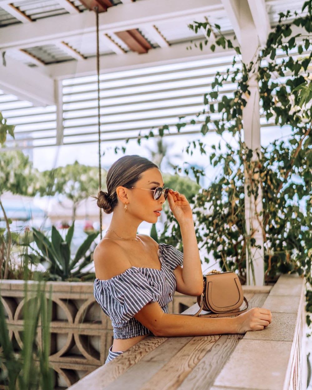woman sitting at counter amongst plants and trees