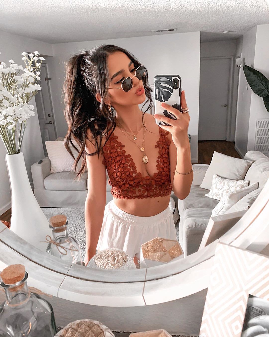 woman in lace bralette taking a selfie in the mirror