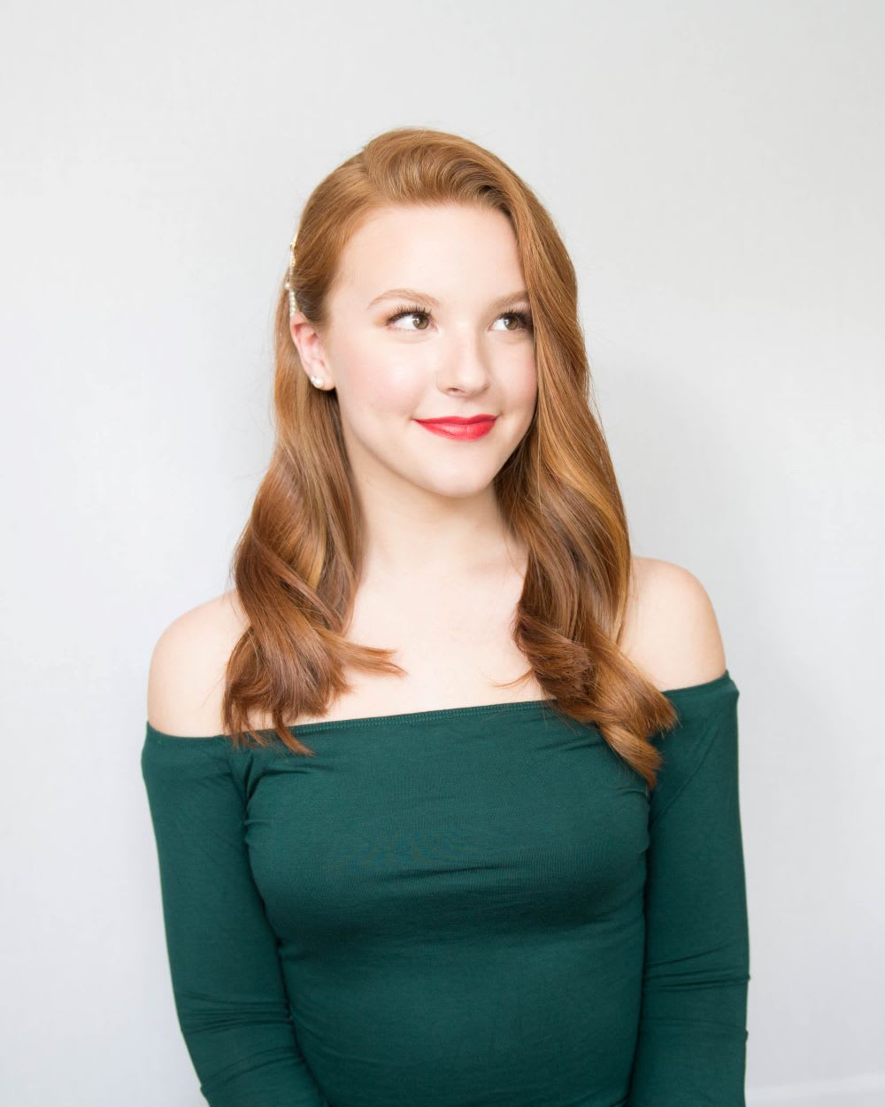 redhead model in off the shoulder green top with old hollywood waves 