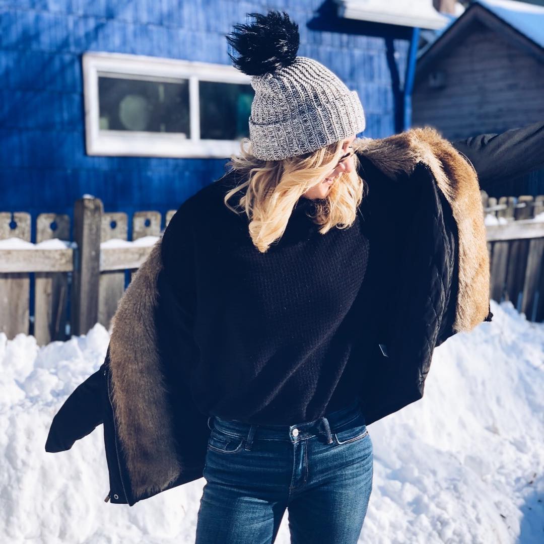 blonde woman in winter clothing and snow for holiday travel deals