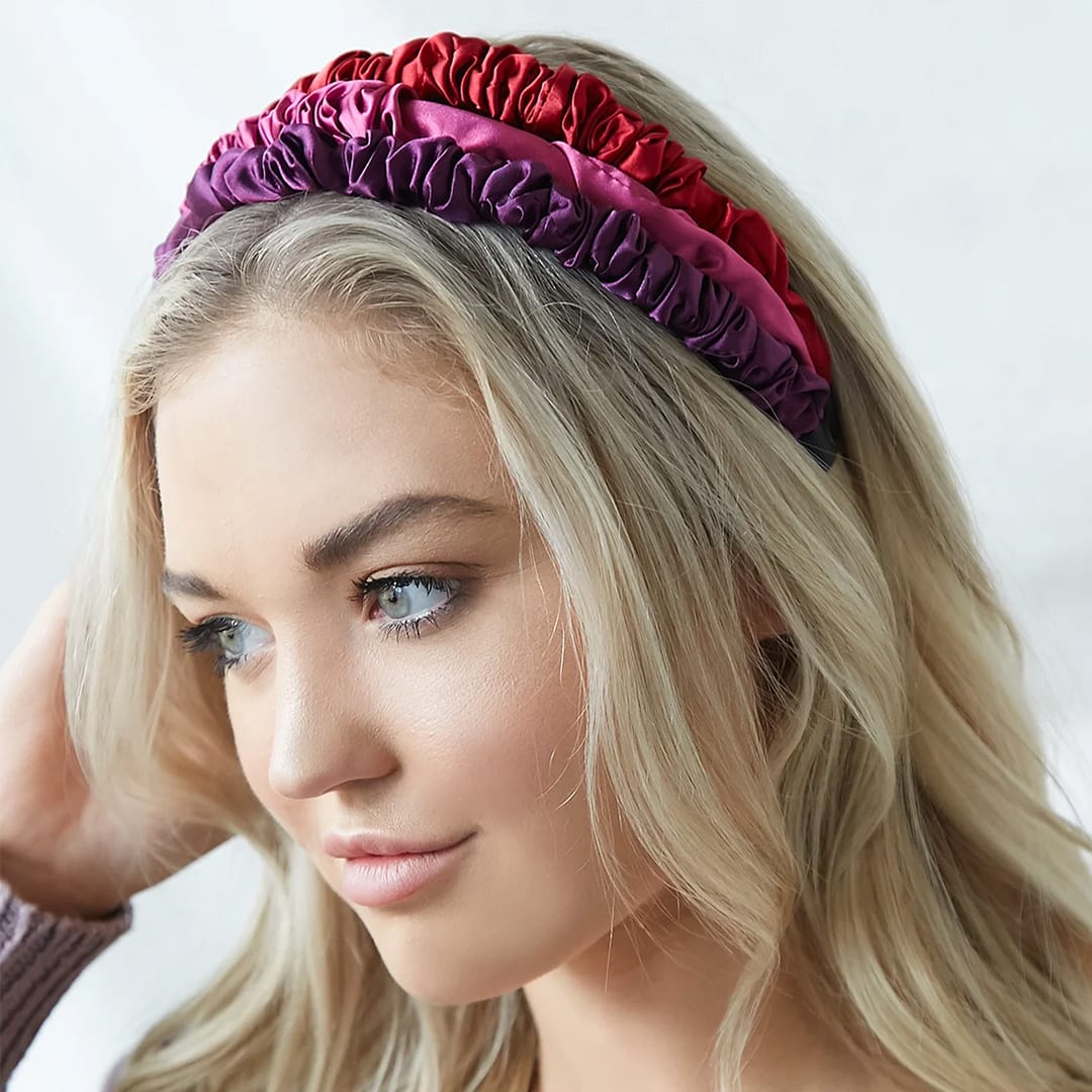 a model wearing three elastic satin headbands in valentines colors