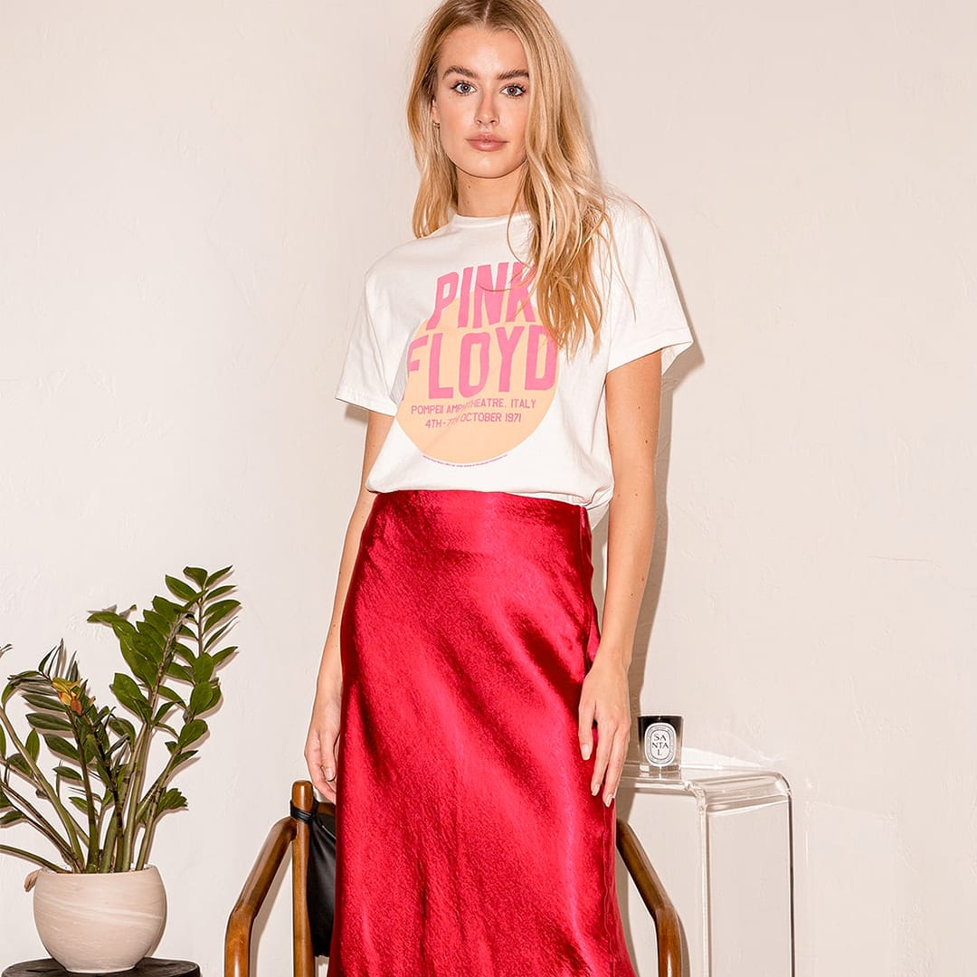 a woman wearing a red satin midi slip skirt with a graphic tee