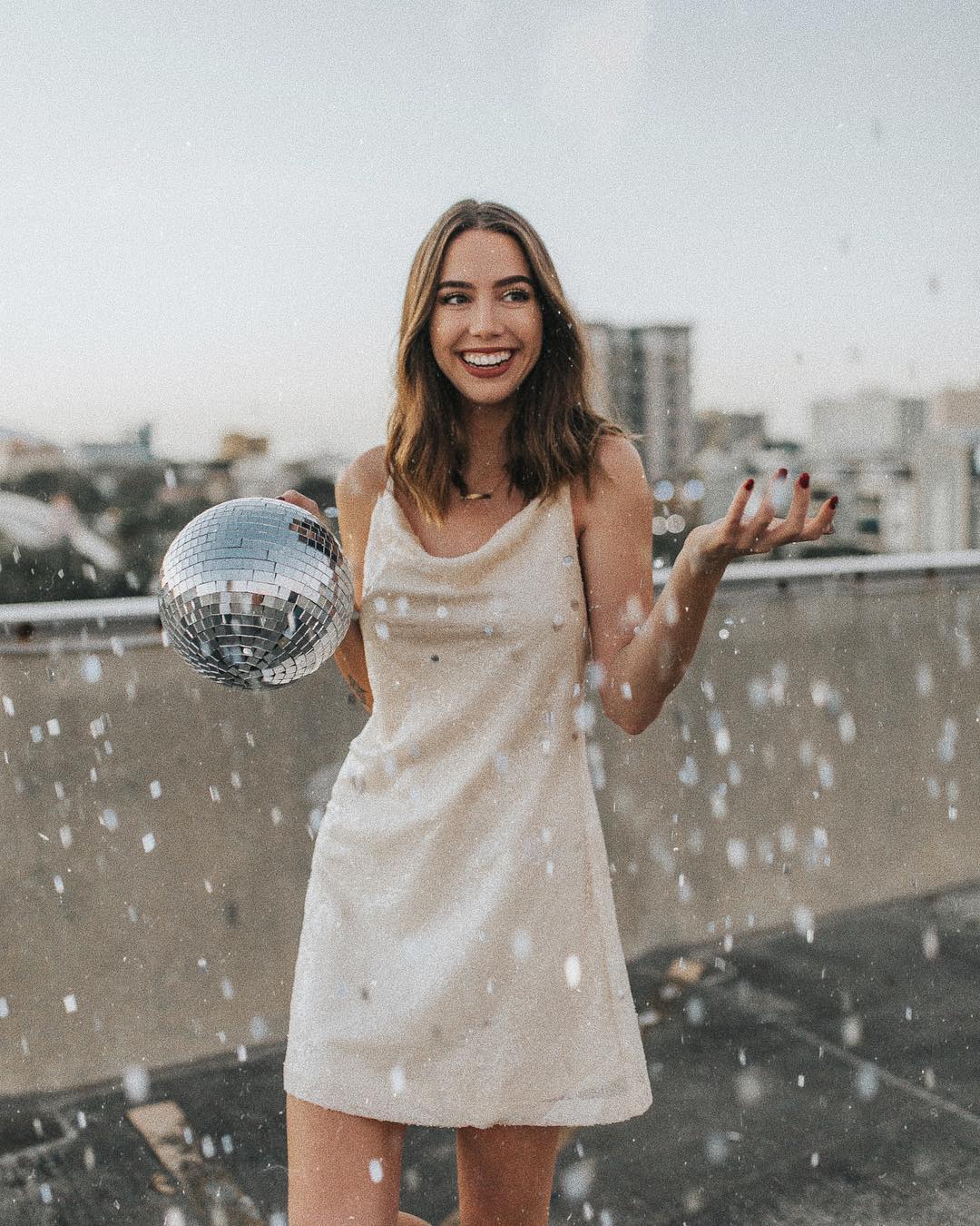 woman holding disco ball for new year's eve