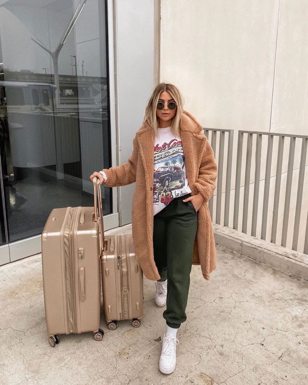 woman in teddy coat with suitcases 