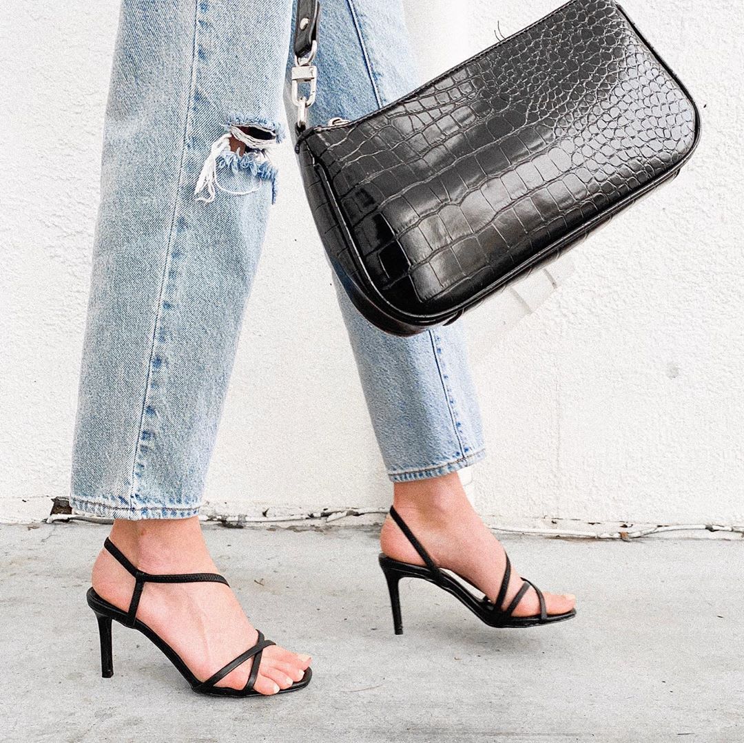 woman's feet in heels and bag