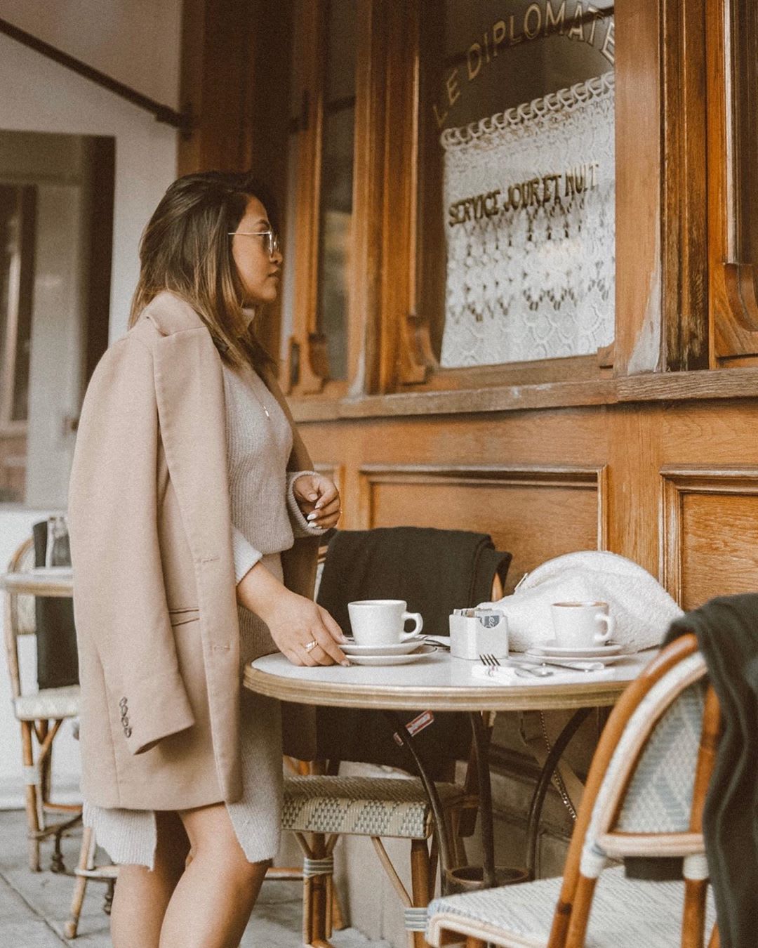 woman in neutral professional outfit at a cafe for freelance business