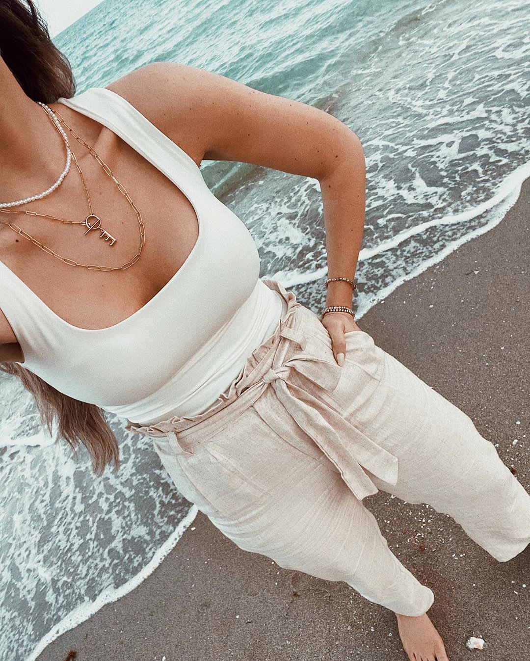 inexpensive places to go for spring break: woman in beach pants and tank in the surf
