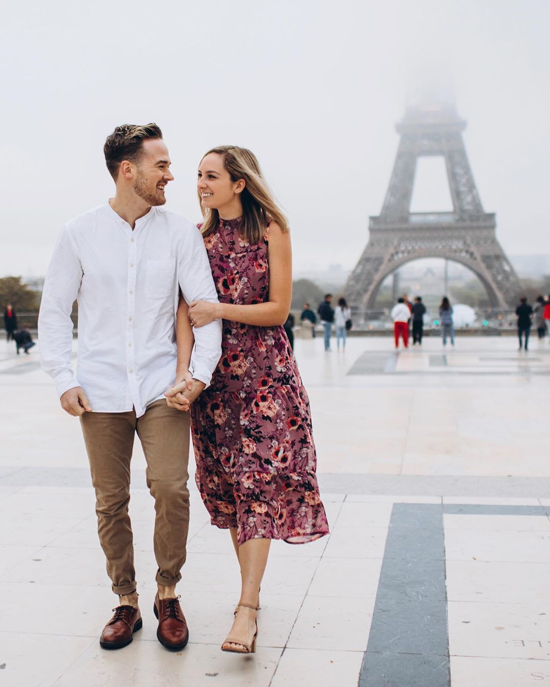 couple walking in paris by eiffel tower
