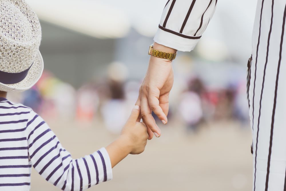mom holding child's hand: divorce tips