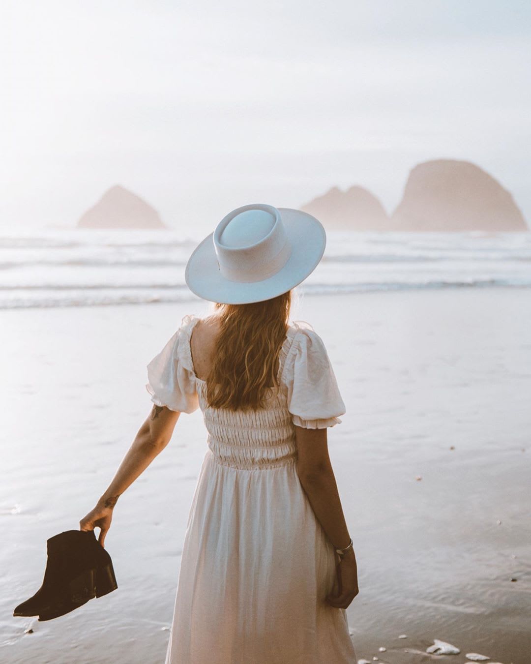 divorce tips and strategies: woman in a smocked dress and hat walking on the beach